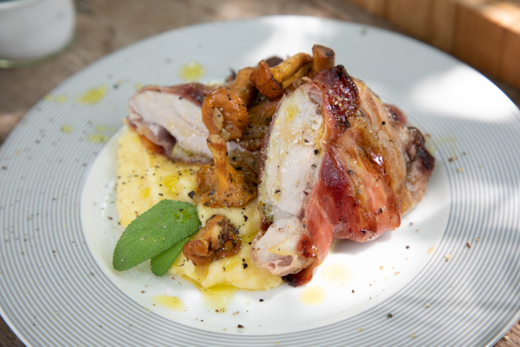 Angerichteter Teller mit Saltimbocca von der Fledermaus, Polenta und Eierschwammerl.